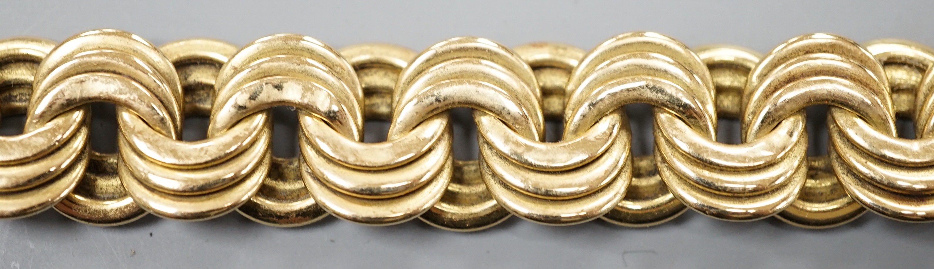 A yellow metal interwoven circular link bracelet, 21cm